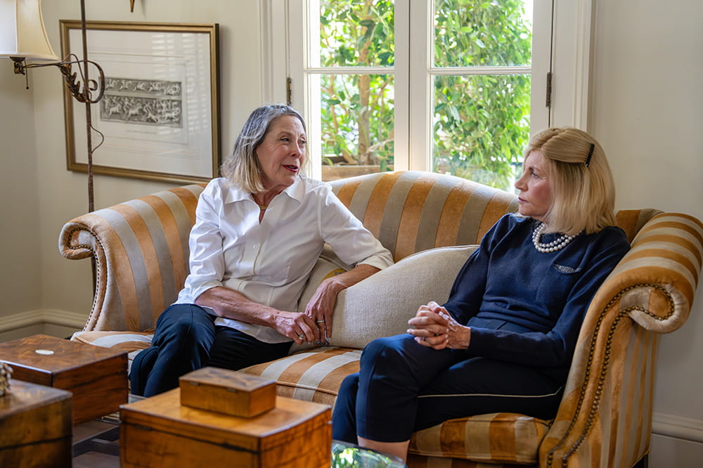 two women chatting on a sofa