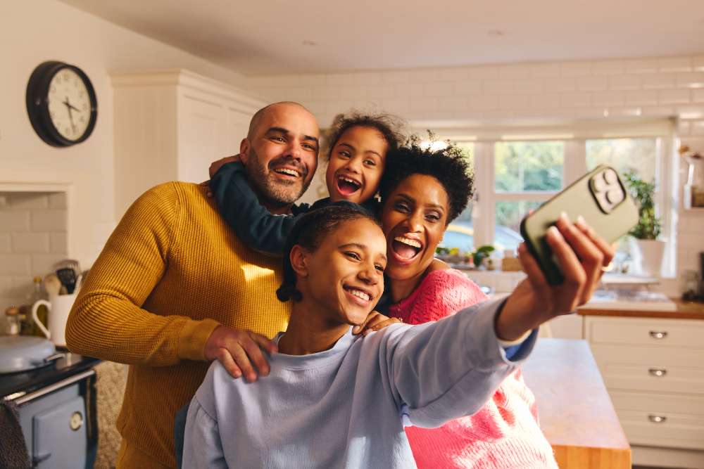 Teenager taking selfie with their smiling family