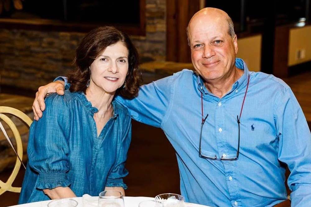 Woman and man in blue shirts pose for a photo.