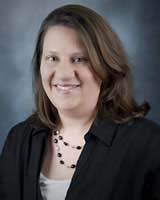 Headshot of woman with brown hair wearing a suit coat